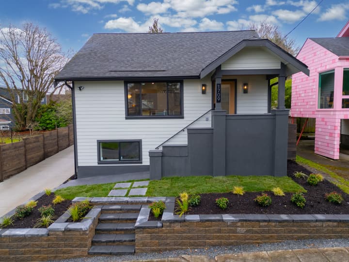 Craftsman exterior with dark siding, white trim and new landscaping