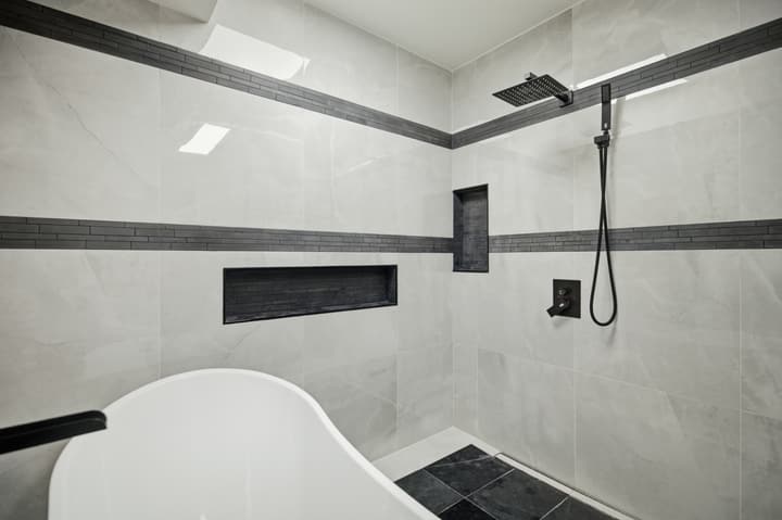 Wet room with freestanding tub and black-framed glass