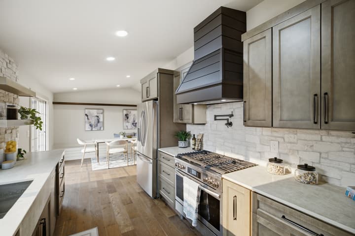 Kitchen with custom hood and stone backsplash