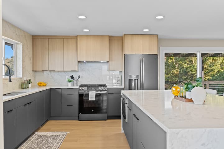 Kitchen with dark lower cabinets and quartz counters